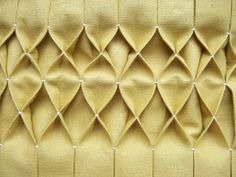 an upholstered headboard made out of fabric with diamond shapes on the back