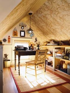 a room with a chair, desk and bookshelf in the middle of it