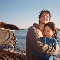 a man and woman hugging on the beach