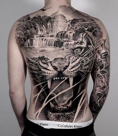 the back of a man's chest with an image of a tiger and waterfall