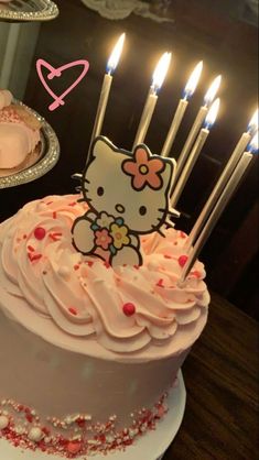 a hello kitty birthday cake with lit candles