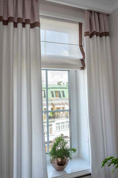 an open window with white curtains and a potted plant