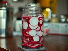 a mason jar filled with red and white pickles