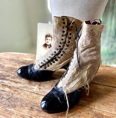 Edwardian era Bellas Hess & Co ladies side lacing two tone boots in shabby weathered and worn condition. Please see photos for condition. Black leather with fabric uppers and stacked wood heel. Measurements: footbed approximately 9" sole from back of heel to toe 8-1/4" heel 2" across ball of foot 2-7/8" Vintage Distressed Boots For Fall, Distressed Vintage Boots With Round Toe, Vintage Distressed Boots With Round Toe, Vintage Patina Boots With Round Toe, Vintage Leather Lace-up Boots With Pointed Toe, Vintage Lace-up Boots With Reinforced Heel, Vintage Ankle Lace-up Boots With Reinforced Toe, Edwardian Boots, Vintage Leather Lace-up Boots With Reinforced Heel