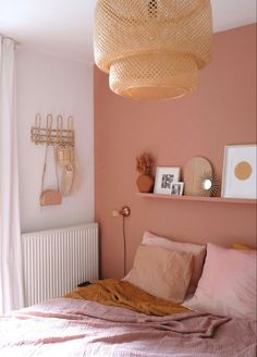 a bedroom with pink walls and gold accents