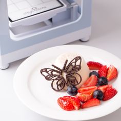 a white plate topped with fruit next to a toaster oven