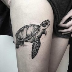 a woman's thigh with a turtle tattoo on it