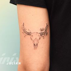 a tattoo on the arm of a man with an animal skull and flowers in it