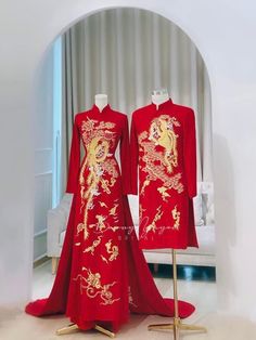 two mannequins dressed in red and gold chinese style outfits with dragon designs on them