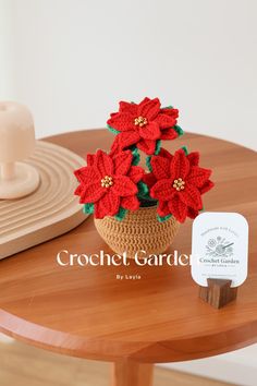 crochet poinsettis in a basket on a table with a card