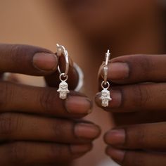 This ancient spiritual symbol carries significance across multiple faiths, countries & generations . Over time, the hamsa has evolved into a universal symbol irrespective of any particular religious view, offering protection, balance & good fortune, and thus becoming an icon of unity. These cute 14mm hoops feature tiny hamsa charms, designed to be stacked and mix & matched with our other interchangeable charm earrings. Hoops can be worn with our without the charms making these a versatile addition to your jewellery box. Hoop size: 14mm Hamsa charms: 10 x 6mm Weight: 2.75g Material: Recycled silver* *Charms are recycled silver, hoops are not. ~ Social Impact ~ The Tiny Hamsa Hoops have been carefully crafted by a small team of marginalised artisans displaced from West Bengal, who have found Spiritual Silver Brass Earrings, Silver Spiritual Dangle Charms, Nickel-free Silver Spiritual Hoop Earrings, Hamsa Hand Earrings, Hamsa Necklace Silver, Resort Accessories, Hamsa Charm, Hand Of Fatima, Recycled Silver