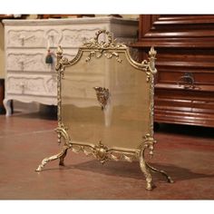 an ornately decorated mirror sits on the floor in front of a chest of drawers