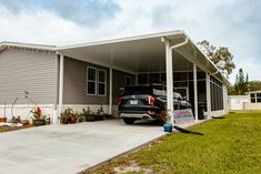 a car is parked in front of a house with a carport attached to it