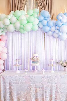 a table topped with lots of balloons and cake