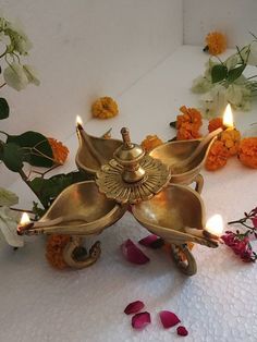 a decorative candle holder with flowers and candles on the floor in front of white background