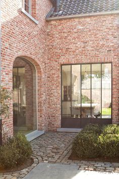 a brick house with glass doors and windows