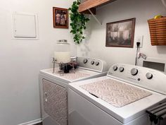 a washer and dryer sitting next to each other in a room with pictures on the wall