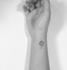 a small four leaf clover tattoo on the wrist