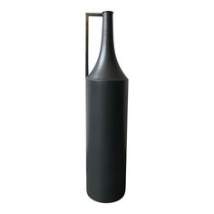 a black vase with a metal handle is shown on a white background, it appears to be empty