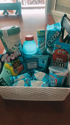 a white basket filled with lots of food on top of a wooden table