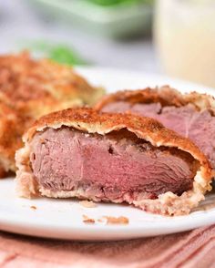 a piece of roast beef on a plate with breaded crusts next to it