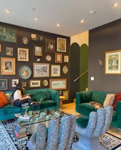 a woman sitting on top of a green couch in a living room filled with furniture