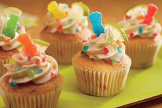 cupcakes with white frosting and colorful sprinkles on a green plate