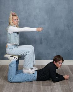 a woman sitting on top of a man who is kneeling down in front of her