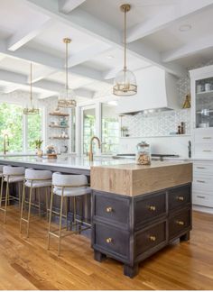 a large kitchen with an island in the middle and lots of stools around it