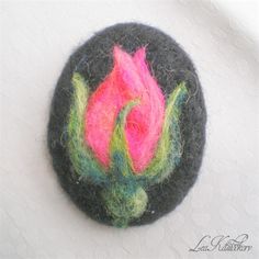 a felt brooch with a pink flower on it