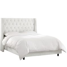 a bed with white linens and buttons on the headboard, in front of a white background