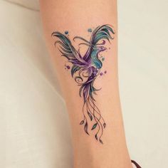 a woman's foot with a tattoo on the side of her leg that has a bird and flowers on it