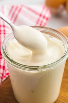 a spoon full of yogurt sitting on top of a wooden table