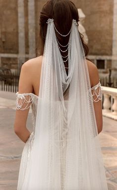 the back of a woman's wedding dress with veil