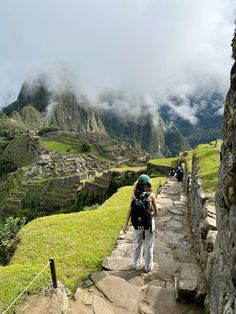 a person with a backpack is walking up some stairs to the top of a mountain