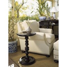 a living room filled with furniture next to a window and potted plant on top of a table