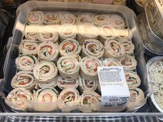 a display case filled with lots of different types of sandwiches and other foods in plastic containers