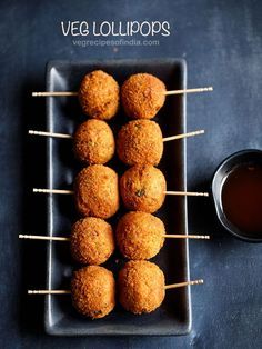 some food is sitting on a plate with toothpicks and dipping sauce next to it