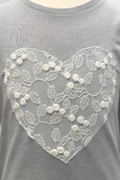 a heart shaped t - shirt with flowers and leaves on the chest, in grey