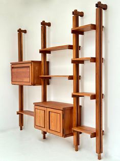 a wooden shelf with drawers and shelves on each side, against a white wall in an empty room