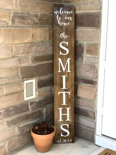 a wooden sign sitting next to a potted plant