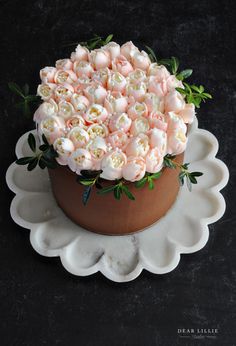 a large bouquet of pink roses in a brown and white bowl on a black surface