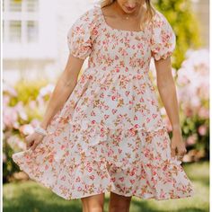 The Mary Anne Dress Is A Floral, Tiered Mini Dress Featuring A Smocked Top And Cuffed Sleeves. Floral Sundress With Smocked Bodice For Day Out, Summer Floral Dress With Smocked Bodice And Puff Sleeves, Spring Mini Length Smocked Dress With Floral Print, Spring Floral Print Smocked Mini Dress, Spring Smocked Square Neck Dress For Garden Party, Spring Square Neck Smocked Dress For Garden Party, Fitted Smock Floral Dress For Spring, Casual Floral Smock Dress For Garden Party, Flowy Mini Dress With Smocked Bodice For Garden Party