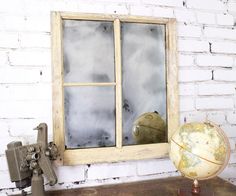 an old window with a globe on the table next to it