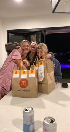 three women hugging each other while holding shopping bags over their heads and smiling at the camera