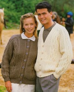 a man and woman standing next to each other in front of a horse pen at a fair