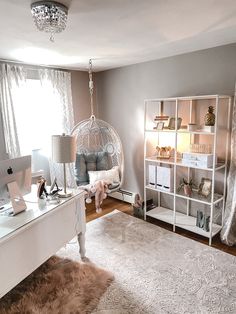 a bedroom with a white desk and hanging chair