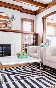 a living room with two couches and a coffee table in front of a fireplace