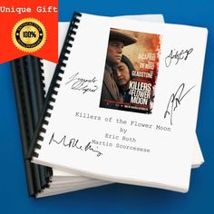 two notebooks with autographs on them sitting next to each other and one has a signed copy of the movie killers of the flower moon