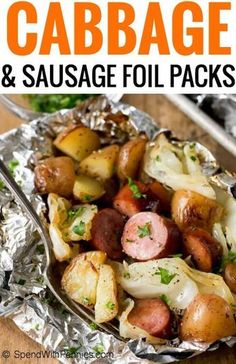 sausage and potatoes in foil packets on a wooden table with text overlay that says cabbage and sausage foil packs